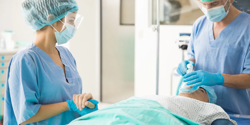 Healthcare professional holding a patient’s hand before surgery, offering comfort and reassurance.