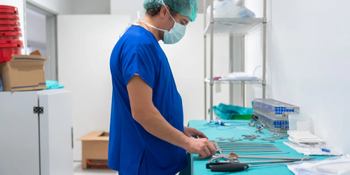 Medical professional preparing and sterilizing surgical instruments in a sterilization unit before a procedure.